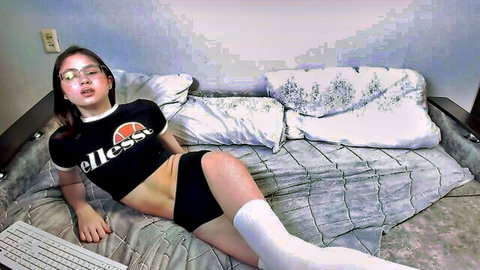 Sinblimer skinny Asian girl in cropped Fila top, shorts and thigh highs posing seductively