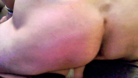 Close-up of pale big ass with red spanking marks, exposed rear in explicit pose