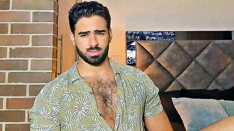Kyler Moss in open green shirt revealing hairy chest, gay cam tease