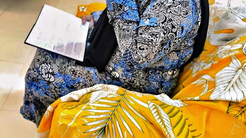Hijab-wearing Arab MILF in colorful dress sitting with big ass curves