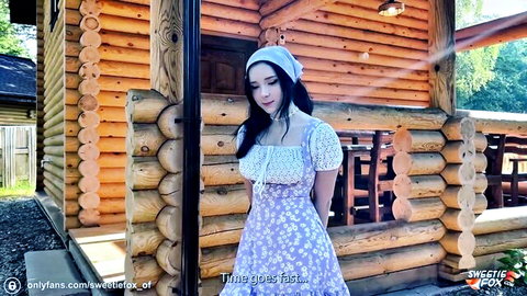 Sweetie Fox as seductive village girl in floral dress outside wooden cabin