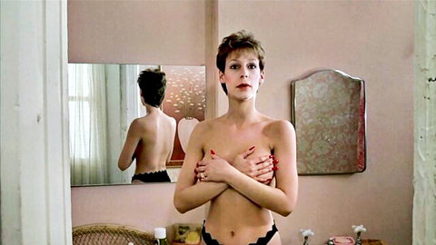 Jamie Lee Curtis topless in black lingerie, arms covering breasts, seductive pose