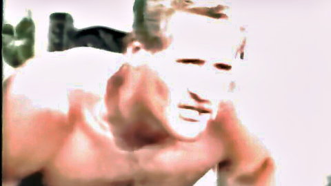 Retro muscular blonde man shirtless, intense stare in vintage XXX video