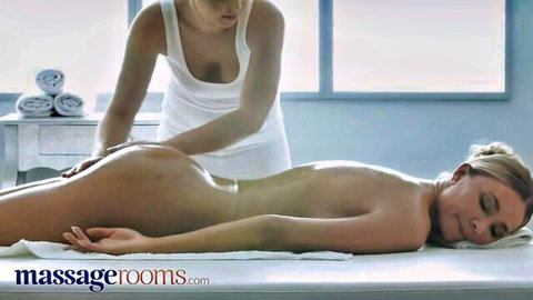 Teana nude on massage table as blonde masseuse oils her ass