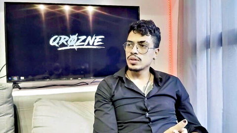 Man with curly hair and glasses discussing haters in lesbian porn content creation