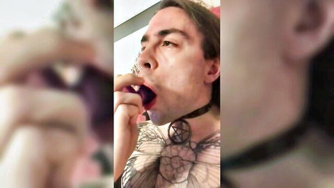 Tattooed man deepthroating purple anal plug, pentagram chest ink