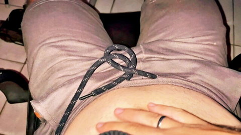 Solo man waking up aroused, hand in open gray shorts