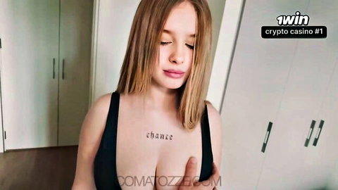 Comatozze blonde model in low-cut top with chest tattoo, teasing cleavage