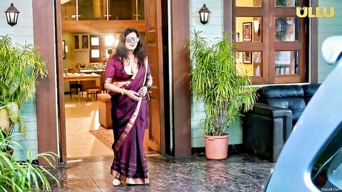 Elegant Indian woman in purple saree posing seductively at doorway, erotic vibe