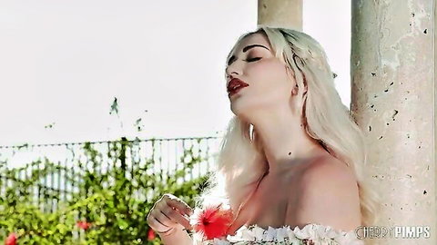 Skye Blue blonde model in romantic red feather top, cleavage tease outdoors