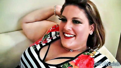Smiling curvy brunette BBW milf in low-cut floral dress showing deep cleavage