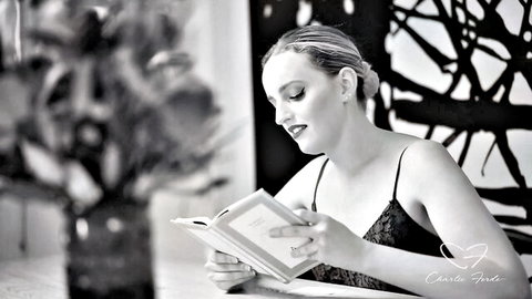 Amber Moore in sexy black lingerie reading erotically, artistic B&W