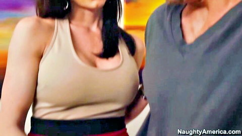 Brunette MILF with huge tits in low-cut tank top standing close to bearded guy