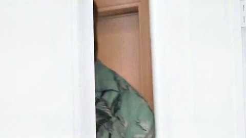 Young brunette with long hair peeking through door in green top