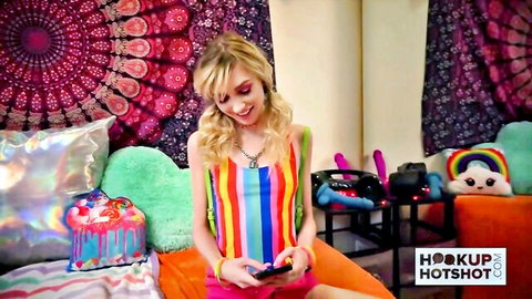 Smiling blonde in striped top and skirt holds phone, HookupHotShot amateur tease
