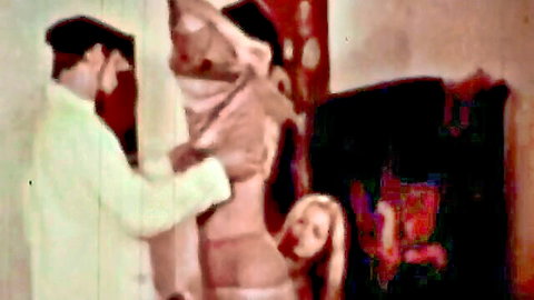 Vintage painter touching semi-nude blonde model in studio pose