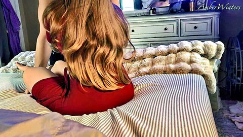 Sexy redhead Amber Winters in tight red dress on bed, teasing back view