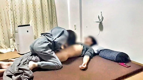 Blurry-faced Japanese couple fucking missionary on futon with clothes pulled aside
