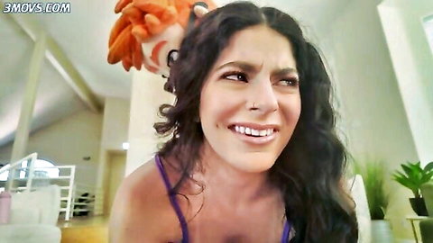 Angel Gostosa smiling playfully in purple top with curly hair in dojo romp