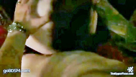 Submissive wrists tightly bound with green ropes in intense BDSM bondage session