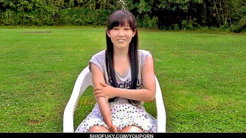 Yui Kasugano smiling in gray tank top and polka dot skirt outdoors
