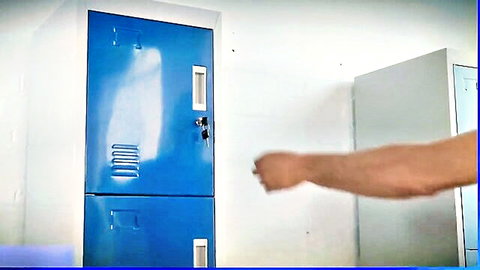 Muscular arm with clenched fist extended in front of blue metal lockers in locker room