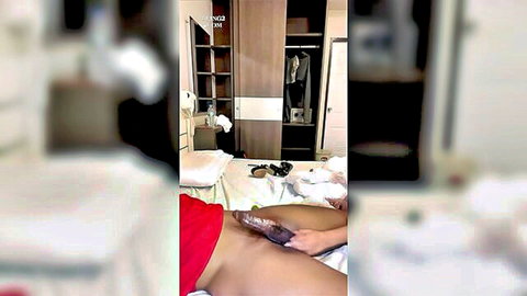 Asian woman thrusting thick purple dildo deep into her wet shaved pussy on bed