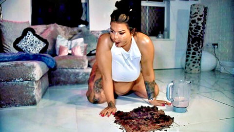 Pregnant tattooed BBW with big tits and ass kneels doggystyle with tongue out licking scat pile on floor