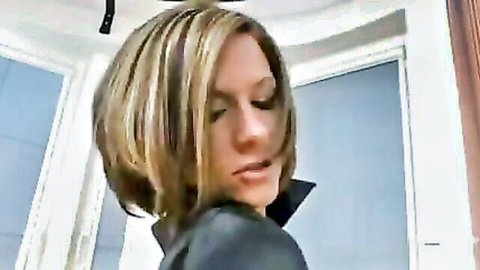 Seductive blonde in leather jacket glances over shoulder in lesbian fetish scene