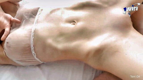 Fit Asian model in sheer white lace lingerie, hands caressing toned body on bed