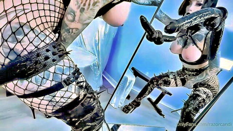 Tattooed cosplay babe in latex and fishnet exposes breasts for solo masturbation play