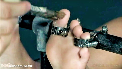 Blonde foot in painful clamps during BDSM domination session