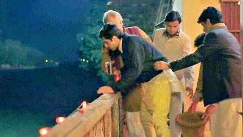 Group of Indian men on nighttime balcony overlooking water