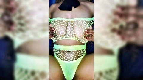 Ebony woman pulls green fishnet top exposing huge tits and dark nipples, legs spread in sheer mesh thong