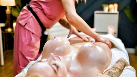 Blonde bombshell gets intimate oil massage from busty masseuse, huge tits exposed