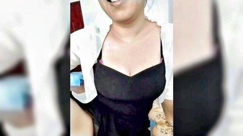 Fangfang-2915 smiling in low-cut black dress with cleavage, webcam tease