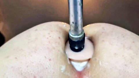 Young woman anally penetrated by fucking machine dildo in hardcore close-up