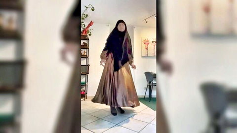 Fatima in hijab and flowing dress dances seductively, arab solo tease
