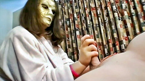 Brunette in gold mask gives soft handjob with red nails