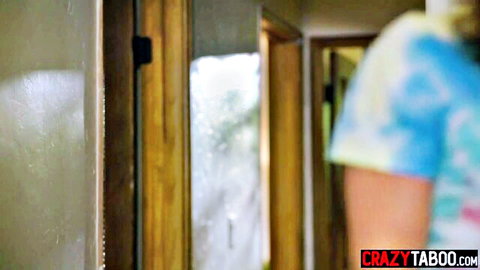 Petite fair-skinned babe in colorful tie-dye top peeking from taboo hallway doorway