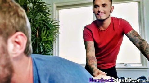 Tattooed short guy in red shirt tops tall bearded boyfriend intimately