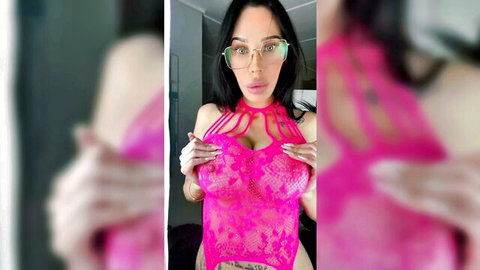 Busty tattooed woman in glasses poses in pink lace lingerie try-on