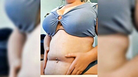 Curvy woman with bloated belly in revealing blue crop top