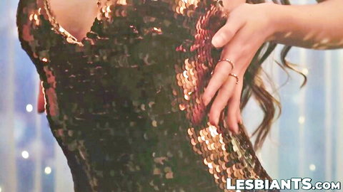 Hazel Moore in sparkling low-cut dress, hand on hip, teasing pose for Tori Easton scene