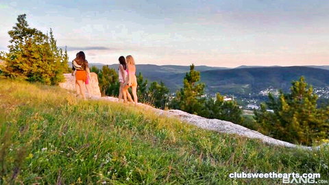 Three sexy women in short skirts hiking outdoors at sunset, teasing views