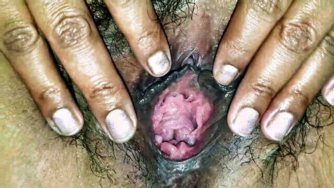 Hairy puffy pussy spread wide open by fingers revealing wet pink gaping vagina