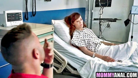 Tattooed redhead MILF in hospital gown lies reclined in bed as bald hunk in red scrubs eyes her hungrily
