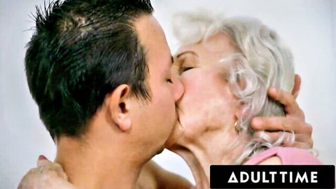 Passionate kiss between elderly white-haired granny and young dark-haired man