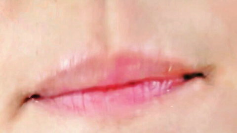 Close-up of redhead babe's glossy pink lips in solo cucumber insertion video
