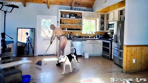Nude harnessed bondage slave mops kitchen floor exposing huge tits and pussy beside dog in pet play